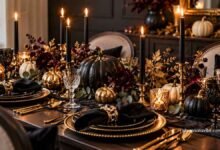 Elegant Halloween tablescape with black candles, pumpkins, gold accents, and sophisticated dinnerware