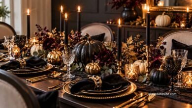 Elegant Halloween tablescape with black candles, pumpkins, gold accents, and sophisticated dinnerware